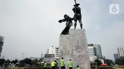 Petugas PPSU DKI Jakarta membersihkan coretan di kawasan Kebon Sirih, Jakarta Pusat, Sabtu (10/10/2020). Dinas kebersihan dari PPSU dan Satpel DLH melakukan penghapusan coretan di fasilitas umum oleh pengunjuk rasa saat demonstrasi tolak Omnibus Law UU Cipta Kerja. (Liputan6.com/Johan Tallo)