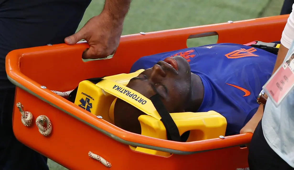 Pemain belakang Belanda, Bruno Martins Indi ditandu keluar lapangan setelah diganjal Tim Cahill (Australia) saat berlaga di babak penyisihan Piala Dunia 2014 Grup B di Stadion Beira Rio, Porto Alegre, Brasil, (18/6/2014). (REUTERS/Marko Djurica) 
