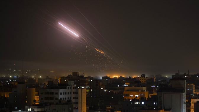 Roket diluncurkan dari Jalur Gaza ke Israel, Jumat (14/5/2021). Mliter Israel mengatakan pasukan darat dan udara menyerang Gaza dalam apa yang tampaknya merupakan serangan terberat. (AP Photo/Khalil Hamra)