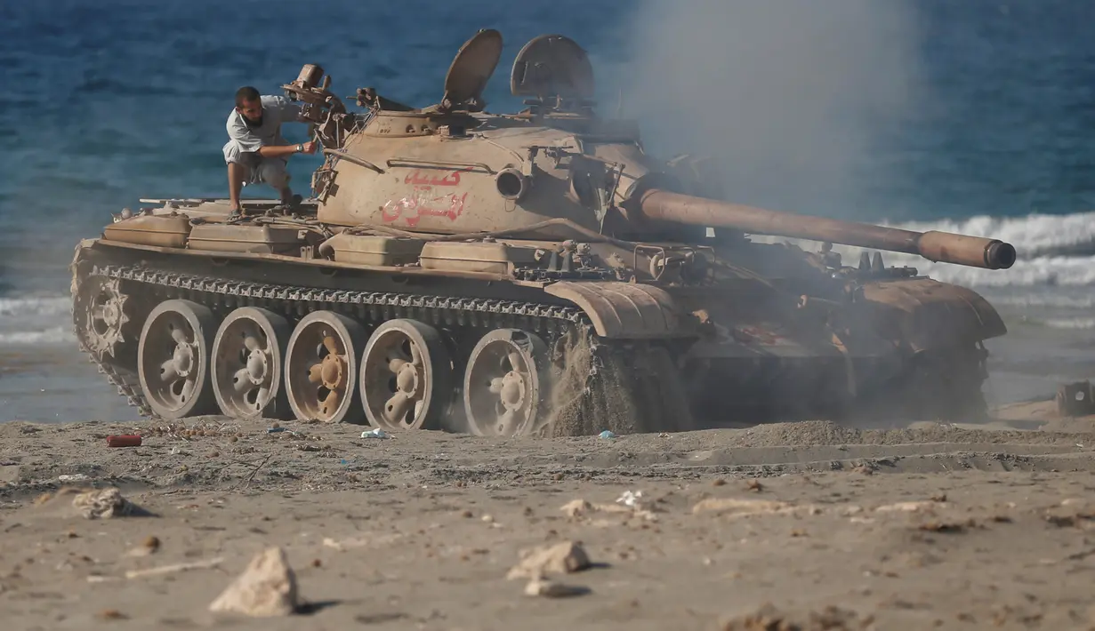 Pasukan Libya mengendarai tank T-55 usai bertempur dengan militian ISIS di Sirte, Libya, (3/8). Tentara Libya yang bersekutu dengan PBB kembali bertempur untuk merebut kembali kota Sirte dari tangan kelompok militan ISIS. (REUTERS/Goran Tomasevic)