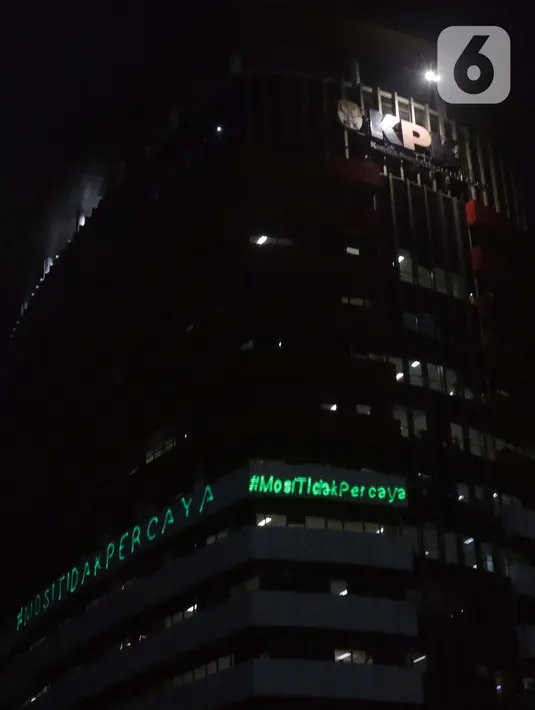 Aktivis Greenpeace menembakkan sinar laser bertuliskan Mosi Tidak Percaya ke gedung Merah Putih KPK, Jakarta, Senin (28/6/2021) malam. Aksi tersebut sebagai bentuk keprihatinan atas upaya pelemahan KPK sejak disahkannya Revisi UU KPK hingga Tes Wawasan Kebangsaan. (Liputan6.com/Helmi Fithriansyah)
