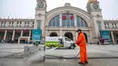 Pekerja menyemprot tempat sampah di luar Stasiun Kereta Api Hankou yang ditutup di Wuhan, Provinsi Hubei, China, Kamis (23/1/2020). Pemerintah China mengisolasi Kota Wuhan yang berpenduduk sekitar 11 juta jiwa untuk menahan penyebaran virus corona. (Chinatopix via AP)