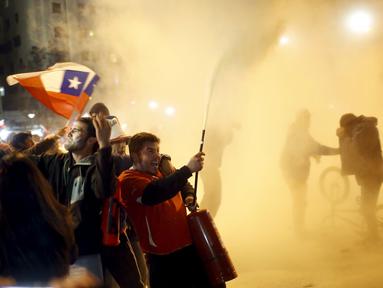 Suporter Cile berpesta di jalanan kota Santiago, Cile, setelah Timnas Cile menang atas Uruguay 1-0 dalam perempatfinal Copa America 2015. (24/6). (REUTERS/Pablo Sanhueza)