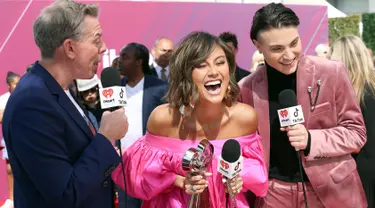 Penyanyi Agnez Mo (tengah) memegang piala iHeartRadio Music Awards 2019 di Los Angeles, California, AS, Kamis (14/3). Agnez Mo berhasil menyabet gelar juara kategori Social Star Award. (Phillip Faraone/Getty Images North America/AFP)