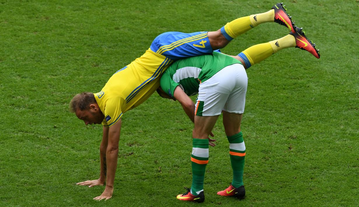 Pemain Irlandia, Shane Long (kanan), duel dengan pemain Swedia, Andreas Granqvist, dalam laga Grup E Piala Eropa 2016 di Stade de France, Saint-Denis, (13/6/2016). (AFP/Paul Ellis)