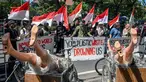 Aktivis lingkungan dari yayasan ECOTON dan mahasiswa di Jawa Timur ikut serta dalam aksi unjuk rasa di depan Konsulat Jenderal Australia di Surabaya pada 11 Juni 2024. (JUNI KRISWANTO/AFP)