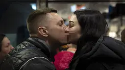 Nicolai (41) mencium istrinya Lolita saat mengucapkan selamat tinggal di kereta menuju Polandia untuk melarikan diri dari perang di stasiun kereta di Lviv, Ukraina, 15 April 2022. Banyak warga Ukraina mencari perlindungan ke Polandia dan negara-negara tetangga lainnya. (AP Photo/Emilio Morenatti)