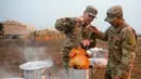 Tentara AS memasak kalkun untuk merayakan Thanksgiving di perbatasan Donna, Texas, Kamis (22/11). Para tentara sedang ditugaskan dalam Operasi Patriot Setia. (Senior Airman Alexandra Minor/U.S. Air Force/Department of Defense via AP)