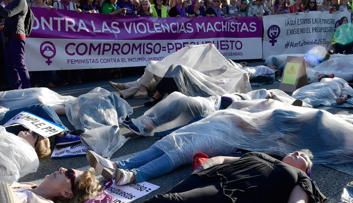 Para pengunjuk rasa membungkus diri dengan plastik saat melakukan aksi di Madrid, Spanyol (16/5). Mereka melakukan aksi yang disebut 'Platform 7N Against the Violence Against Women' untuk memerangi kekerasan terhadap perempuan. (AFP/Javier Soriano)