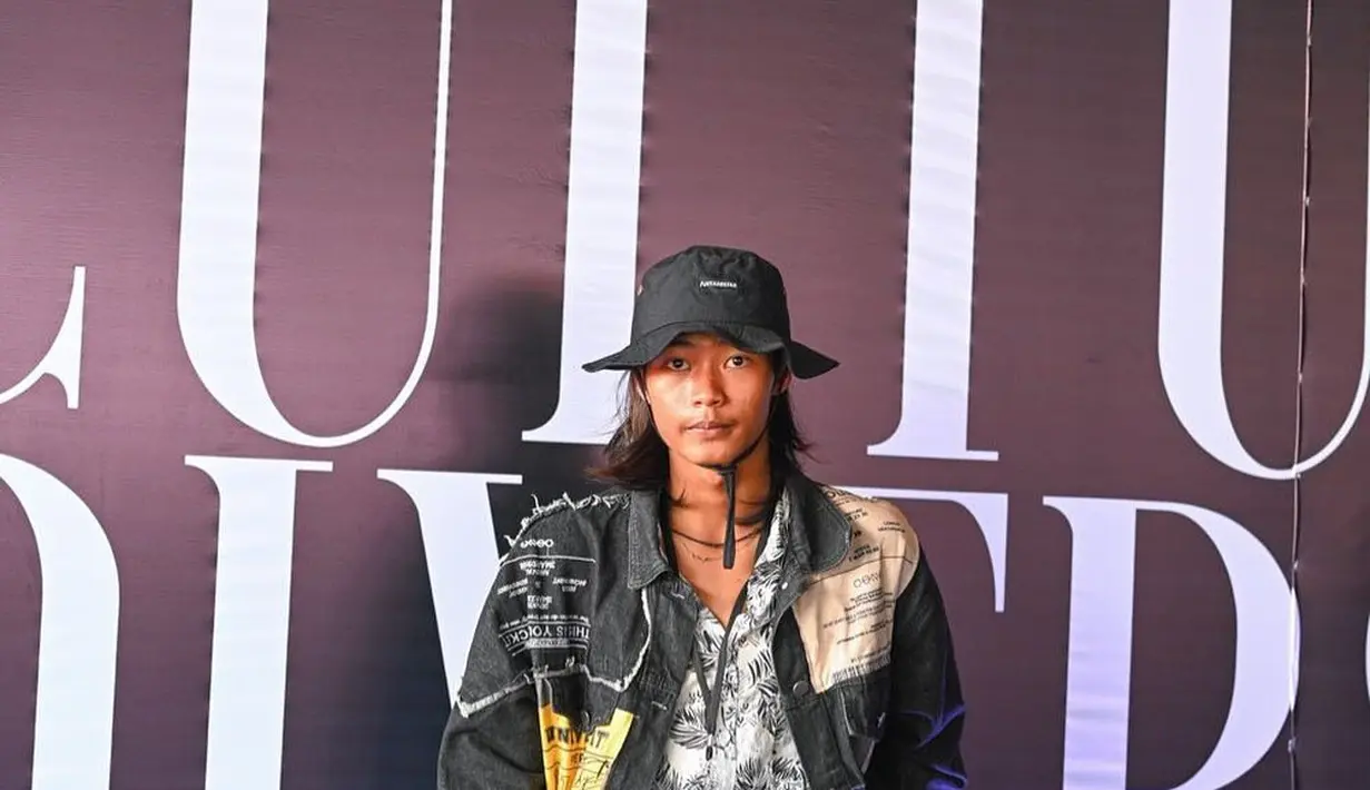 Mengenakan celana jin biru tua oversized yang dipadu dengan kemeja monokrom motif daun kelapa, gaya Bonge Citayam makin paripurna berkat jaket hitam berbahan denim. Bagai selebritas jalanan, jaket itu ditambal sejumlah kain motif tulisan. Rambut gondrong Bonge dibiarkan terurai dan dibingkai topi hitam putih. Jelas, ini menyita perhatian publik. (Foto: Dok. Instagram @jfff_info)