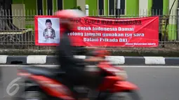 Pengendara melintasi spanduk tolak penggunaan isu SARA dalam Pilkada DKI di Jalan Panjang, Jakarta, Rabu (2/11). Jelang kompetisi Pilkada DKI 2017, spanduk imbauan tepis isu SARA mulai bertebaran. (Liputan6.com/Yoppy Renato)