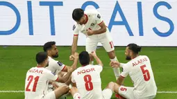 Pemain Yordania, Yazan Al-Naimat (tengah) melakukan selebrasi bersama rekan-rekannya setelah mencetak gol pertama timnya ke gawang Korea Selatan pada laga semifnial Piala Asia 2023 di Ahmad Bin Ali Stadium, Doha, Qatar, Selasa (06/02/2024). (AFP/Karim Jaafar)
