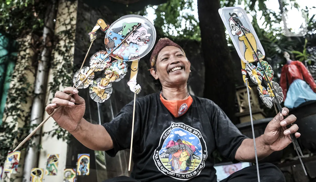 Seniman Iskandar Hardjodimuljo menjadi dalang memainkan wayang uwuh di kawasan Cawang, Jakarta, Kamis (29/10/2020). Wayang uwuh dicetus oleh ayah dua anak ini pada 2013. (merdeka.com/Iqbal S. Nugroho)
