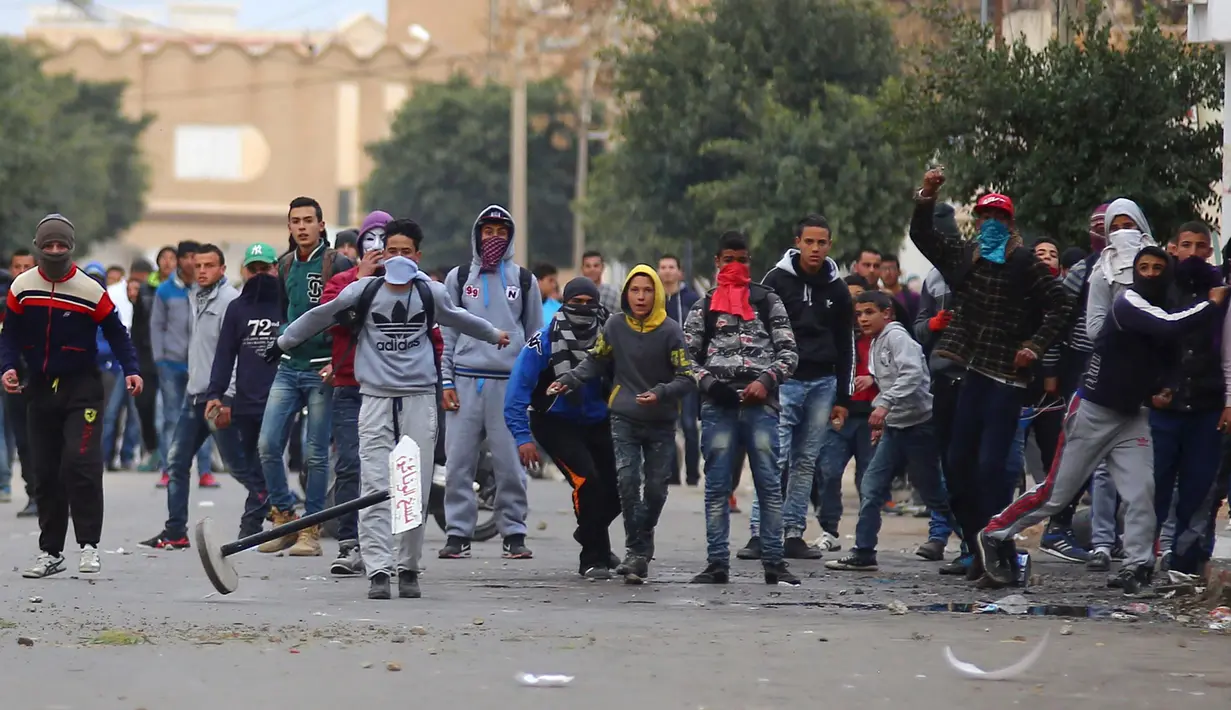 Para pengunjuk rasa melakukan aksi protes di luar kantor pemerintah setempat di Kasserine, Tunisia, Kamis (21/1). Para pengangguran muda turun ke jalan memprotes keterpurukan ekonomi dan sulitnya lapangan kerja. (REUTERS/Amine Ben Aziza)