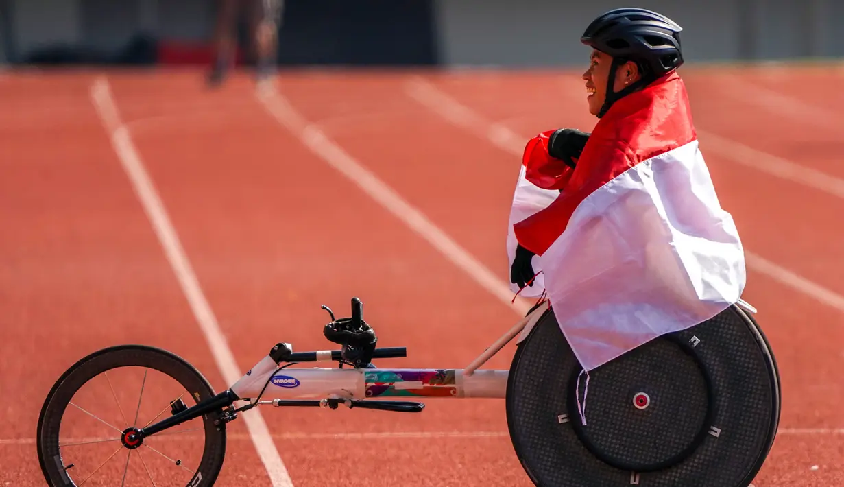 Atlet balap kursi roda Maria Goreti melakukan selebrasi usai memenangi final balap kursi roda 400 meter putri 11th ASEAN Para Games 2022 di Stadion Manahan, Solo, Jawa Tengah, Kamis (4/8/2022). Maria Goreti meraih medali emas pada final tersebut. (INASPOC/Feri Setiawan)