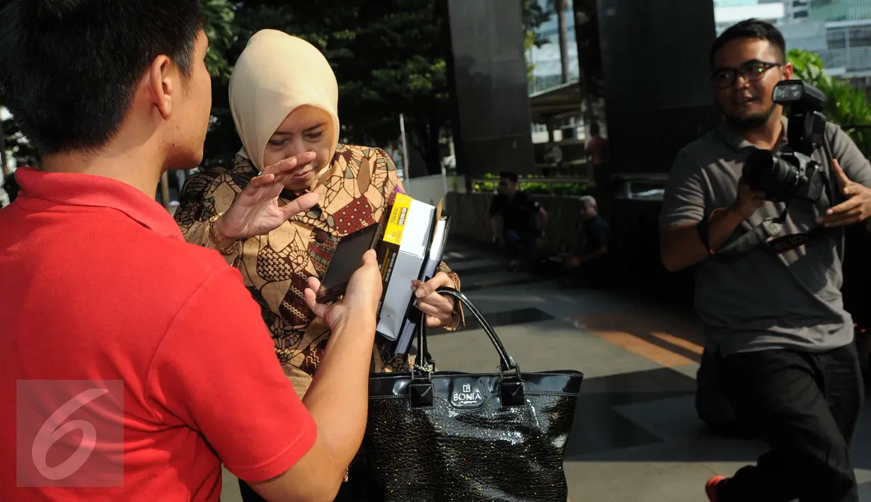 Panitera PN Jakarta Utara Rina Pertiwi berusaha menghindari awak media seusai menjalani pemeriksaan penyidik KPK, Jakarta, Selasa (2/8). Rina diperiksa sebagai saksi kasus dugaan suap yang melibatkan pedangdut Saipul Jamil. (Liputan6.com/Helmi Afandi)