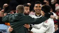 Ada kejadian menarik setelah gol ketiga MU yang dicetak oleh Bruno Fernandes. Seorang suporter lolos dari kawalan petugas dan melakukan selebrasi bersama Bruno Fernandes, Casemiro, dan Lisandro Martinez. (AFP/Darren Staples)