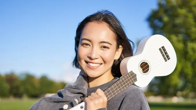 tersenyum mencintai diri sendiri memegang ukulele