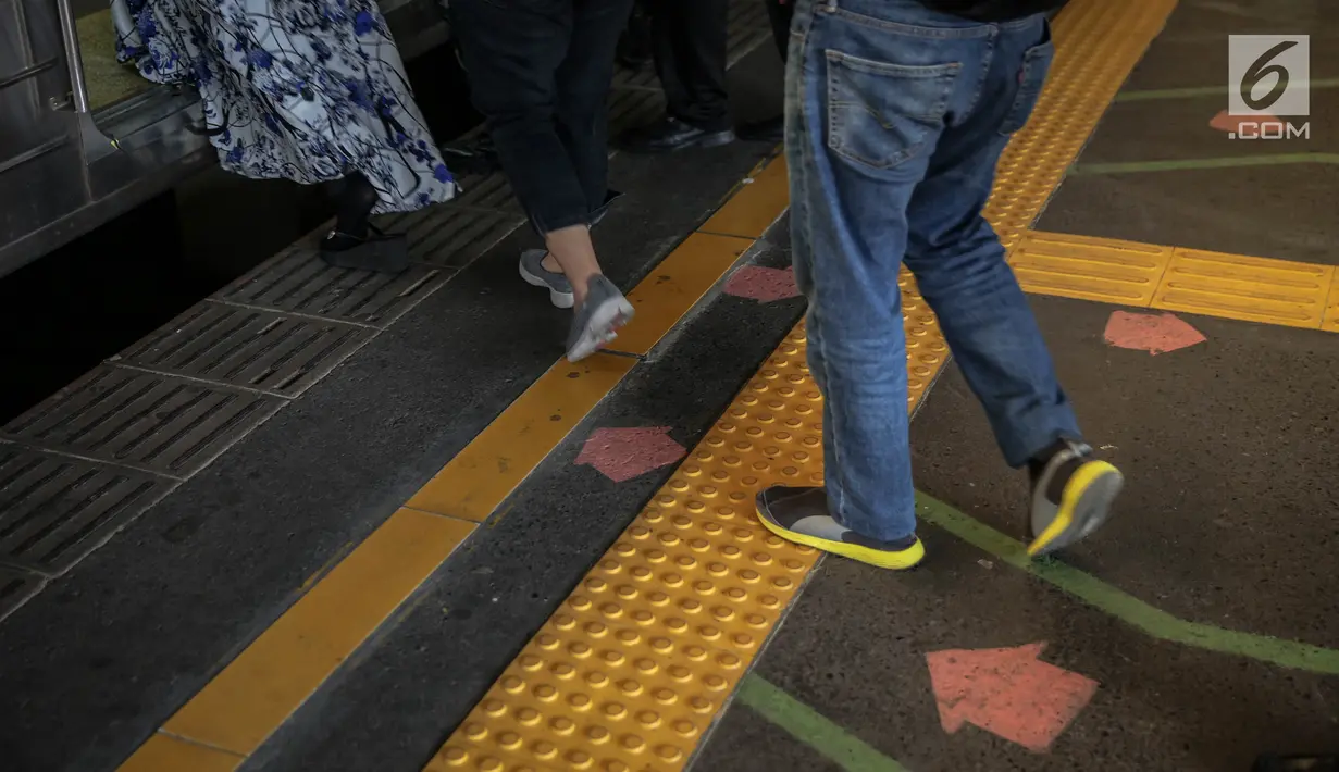 Garis antrean penumpang di Stasiun Juanda, Jakarta, Kamis (10/8). Uji coba garis antrean penumpang juga guna mengurangi bahaya kecelakaan seperti penumpang terjatuh dan terdorong saat keluar masuk KRL. (Liputan6.com/Faizal Fanani)