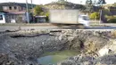 Sebuah mobil melaju melewati kawah bom setelah ditembaki oleh artileri Azerbaijan selama konflik militer dengan Armenia di kota garis depan Martakert, wilayah separatis Nagorno-Karabakh, Senin (19/10/2020). Pertempuran di Nagorno-Karabakh berkecamuk selama lebih dari tiga minggu. (AP Photo)