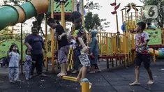 Anak-anak didampingi orangtua bermain di RPTRA Bhineka Jakarta Selatan, Sabtu (30/7/2022). Selain menjadi alternatif mengisi libur bersama keluraga, taman juga menjadi ruang bagi warga untuk berinteraksi sosial sekaligus mengeduksi anak untuk bermain bersama teman-teman dengan wahana yang tersedia. (Liputan6.com/Johan Tallo)