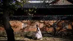 Orang-orang mengenakan Hanbok (pakaian tradisional Korea) saat mereka mengunjungi halaman Istana Gyeongbokgung di Seoul pada tanggal 2 November 2023. (ANTHONY WALLACE/AFP)