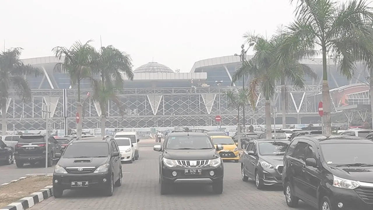 Suasana di parkiran Bandara SSK II Pekanbaru yang diselimuti kabut asap hasil kebakaran hutan dan lahan.