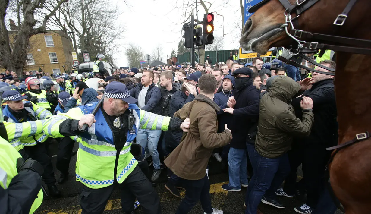 Suasana bentrokan suporter Millwall dengan petugas kepolisian sebelum pertandingan perempat final Piala FA antara Tottenham Hotspur melawan Millwall di White Hart Lane, London, (12/3). (Yui Mok//PA via AP)