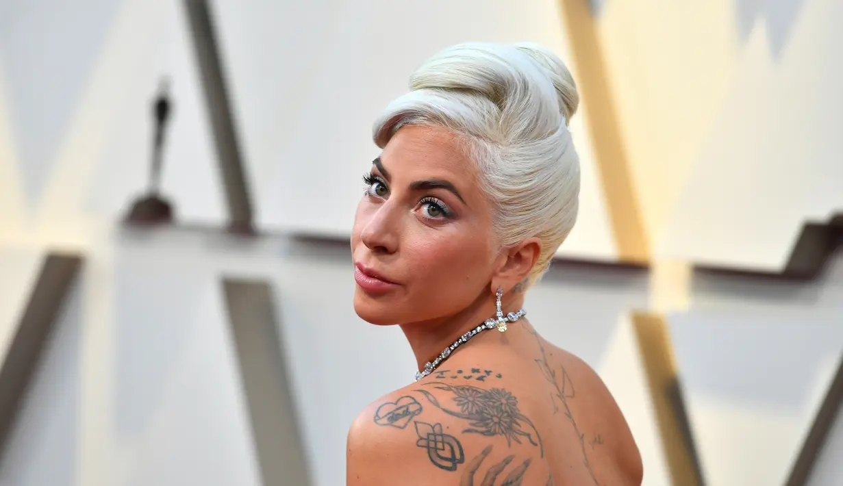 Penyanyi dan aktris Lady Gaga menghadiri perhelatan Oscar 2019 di Dolby Theatre, Los Angeles, Minggu (24/2). Lady Gaga makin terlihat menawan dengan rambut blonde-nya lantaran mengenakan perhiasan dengan kilau sinar. (Jordan Strauss/Invision/AP)