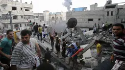 Beberapa warga Palestina berusaha mencari korban yang terjebak reruntuhan bangunan yang hancur akibat serangan udara militer Israel di kota Rafah, Palestina, (11/7/2014). (REUTERS/Ibraheem Abu Mustafa)
