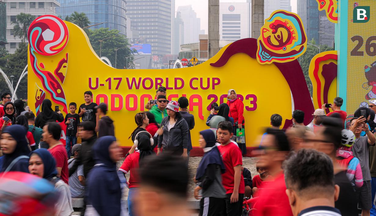 Sejumlah warga dengan antusias mengabadikan momen dengan latar tulisan Piala Dunia U-17 2023 dalam rangkaian acara Trophy Experience saat Hari Bebas Kendaraan Bermotor di kawasan Bundaran HI, Minggu (15/10/2023). (Bola.com/Bagaskara Lazuardi)