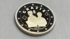 Koin 2 Euro yang didedikasikan untuk profesi tenaga kesehatan yang memerangi pandemi Covid-19 di percetakan uang negara Italia, di Roma, Kamis (21/1/2021). Koin itu bergambar seorang pria dan perempuan mengenakan seragam medis dan masker serta tulisan ‘Grazie’ atau Terima Kasih (AP/Andrew Medichini)