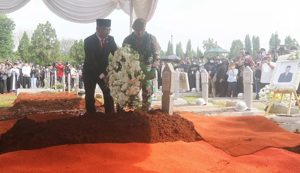 Menteri Koordinator Bidang Pembangunan Manusia dan Kebudayaan, Muhadjir Effendy, meletakkan karangan bunga di atas pusara Almarhum Azyumardi Azra di Taman Makam Pahlawan Kalibata, Jakarta, Selasa (20/9/2022). Tokoh-tokoh negara tampak mengikuti prosesi pemakaman. (Liputan6.com/Herman Zakharia)
