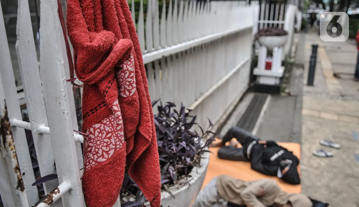 Sebuah handuk milik imigran tergantung di pagar Kantor UNHCR Kebon Sirih, Jakarta Pusat, Kamis (1/4/2021). Imigran yang terdiri atas orang dewasa hingga anak-anak ini tidur di pinggir jalan menuntut agar proses perpindahan ke negara negara tujuan segera dipercepat. (merdeka.com/Iqbal S Nugroho)