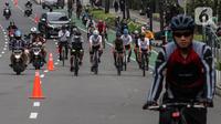Warga bersepeda melintasi kawasan Sudirman - Thamrin saat akhir pekan, Jakarta, Minggu (20/2/2022). Aktivitas warga di kawasan tersebut relatif ramai saat Pemberlakuan Pembatasan Kegiatan Masyarakat (PPKM) level tiga di ibu kota. (Liputan6.com/Johan Tallo)