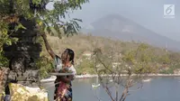 Warga bersembahyang di Pura kawasan Amed dengan latar belakang Gunung Agung di Karangasem, Bali, Rabu (27/9). Sebagian warga yang tinggal di lereng timur laut Gunung Agung masih belum mengungsi meski gunung berstatus awas. (Liputan6.com/Gempur M Surya)