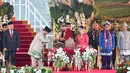 Setelah di pagi harinya Presiden dan Ibu Negara memilih mengenakan baju adat dari daerah Kutai, di Upacara Penurunan Bendera, Jokowi dan Iriana Jokowi tampil kompak serba merah dengan baju adat Banjar. [Foto: Instagram/jokowi]