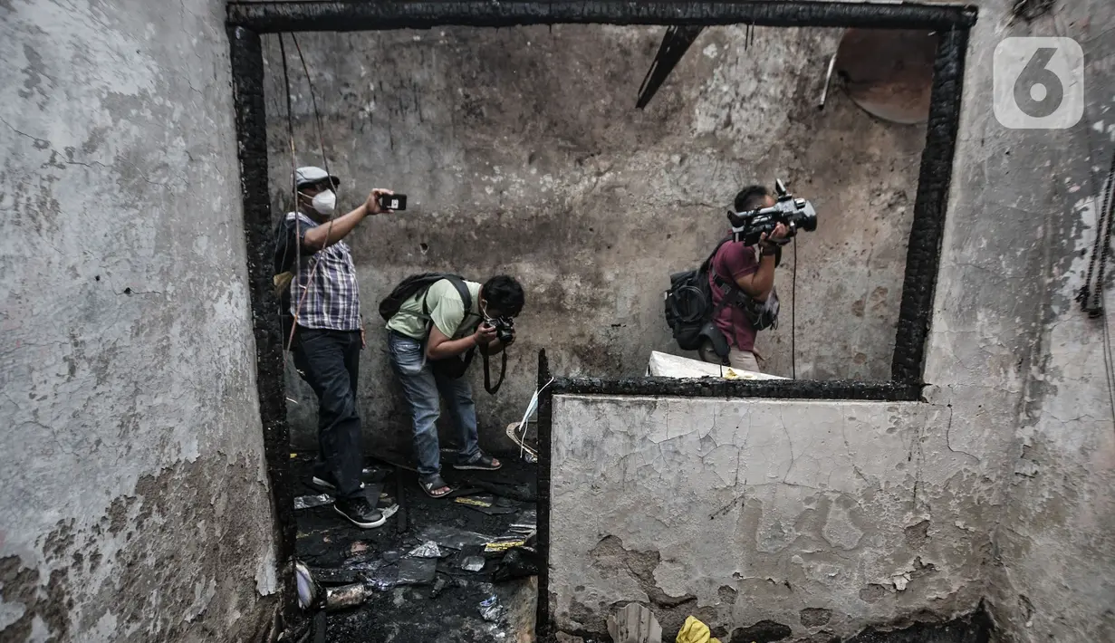 Awak media mengambil gambar di lokasi kebakaran yang melanda rumah kontrakan di Jalan Pisangan Baru III, RT 006/010, Matraman, Jakarta, Kamis (25/3/2021). Kebakaran yang diduga terjadi karena korsleting listrik tersebut menghanguskan 5 rumah kontrakan. (merdeka.com/Iqbal S. Nugroho)