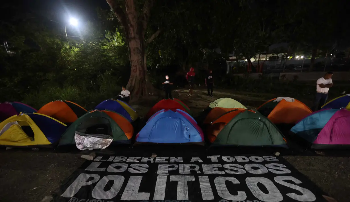 Tenda-tenda yang didirikan oleh kerabat tahanan politik terlihat di luar penjara El Rodeo I di Guatire, Negara Bagian Miranda, sekitar 30 kilometer sebelah timur Caracas, Venezuela, pada 12 Januari 2026. Warga Venezuela masih menanti pembebasan lebih banyak tahanan politik yang dipenjara atas perintah Presiden Nicolas Maduro. (Pedro MATTEY/AFP)