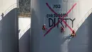 Aktivis Greenpeace melukis "DIRTY" ke sebuah silo di kilang Wilmar International di Bitung, Sulawesi Utara, Selasa (25/9). (Dhemas Reviyanto, Nugroho Adi Putera, Jurnasyanto Sukarno/Greenpeace Southeast Asia/AFP)