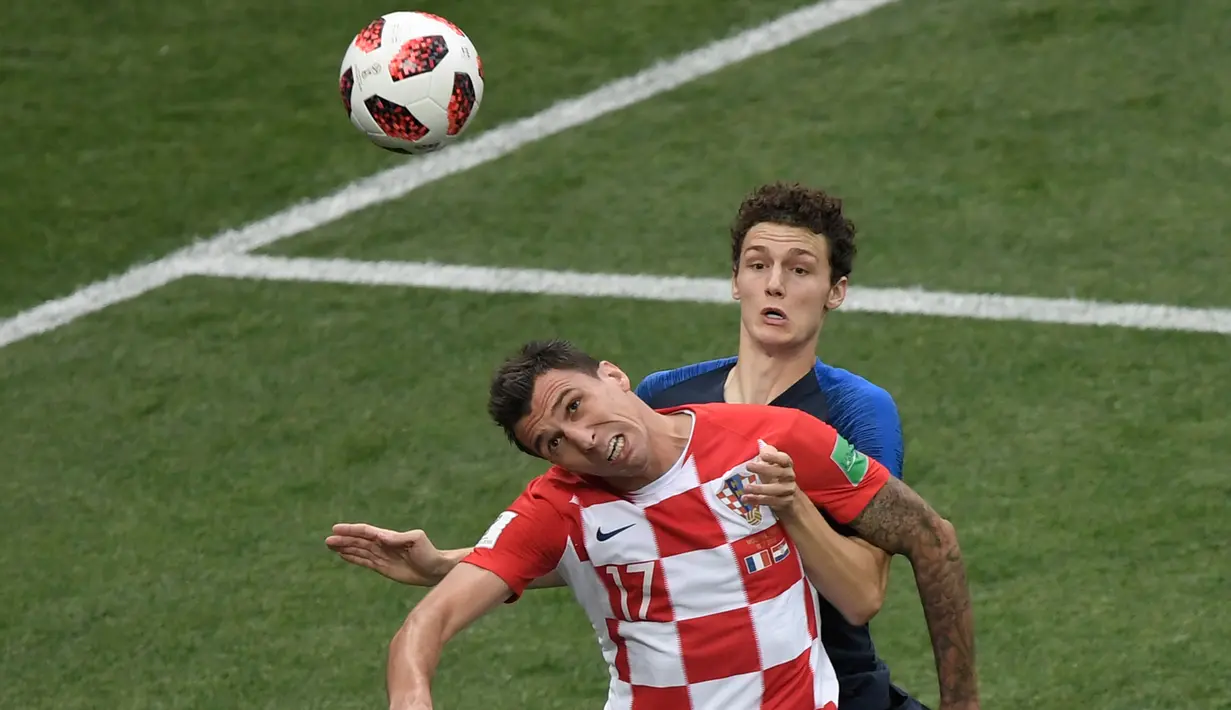 Pemain depan Kroasia Mario Mandzukic (depan) menyundul bola saat berebut dengan bek Prancis Benjamin Pavard pada pertandingan sepak bola final Piala Dunia 2018 di Stadion Luzhniki Moskow, (15/7). (AFP PHOTO / Gabriel Bouys)
