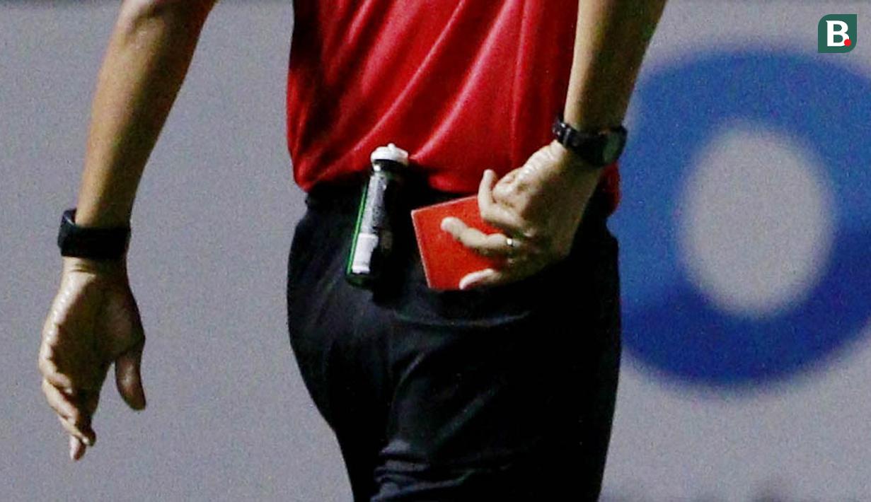 Wasit asal Jawa Barat ini tampak mengeluarkan kartu merah dari saku celana nya. (Bola.com/M Iqbal Ichsan)