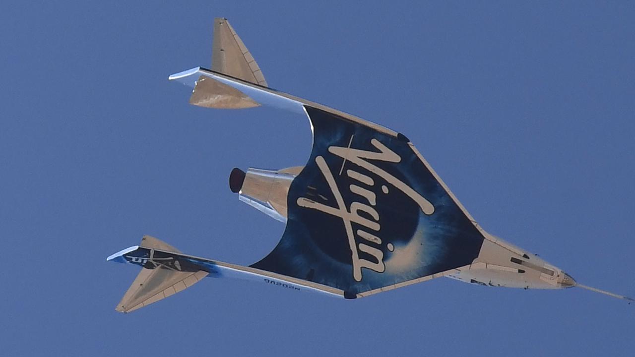 Pesawat ruang angkasa Virgin Galactic SpaceShipTwo kembali ke Bumi setelah kapal induk memisahkannya di atas langit Spaceport America, dekat Truth and Consequences, New Mexico pada 11 Juli 2021 dalam perjalanan ke cosmos. Patrick T. FALLON / AFP