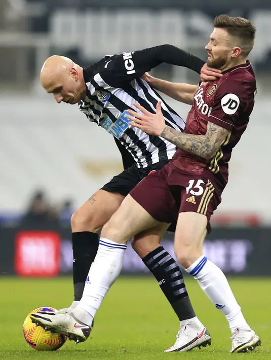 Pemain Newcastle United Jonjo Shelvey (kiri) berebut bola dengan pemain Leeds United Stuart Dallas pada pertandingan Liga Inggris di St. James Park, Newcastle, Inggris, Selasa (26/1/2021). Newcastle United menang 2-1 atas Leeds United. (Lyndsey Parnaby/Pool via AP)