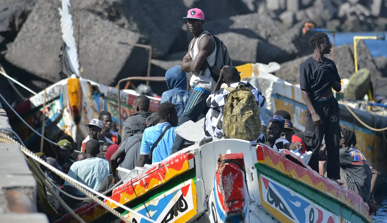 Para imigran menunggu untuk turun dari kapal di dermaga La Restinga, di kotamadya El Pinar di Pulau Canary El Hierro, pada 31 Oktober 2023. (STRINGER / AFP)