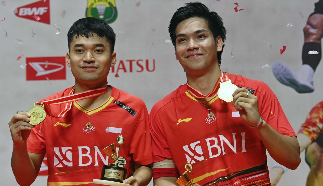 Ganda putra Indonesia, Leo Rolly Carnando (kiri) dan Daniel Marthin berpose di podium kemenangan turnamen bulu tangkis Indonesia Masters di Jakarta, 28 Januari 2024. (ADEK BERRY/AFP)