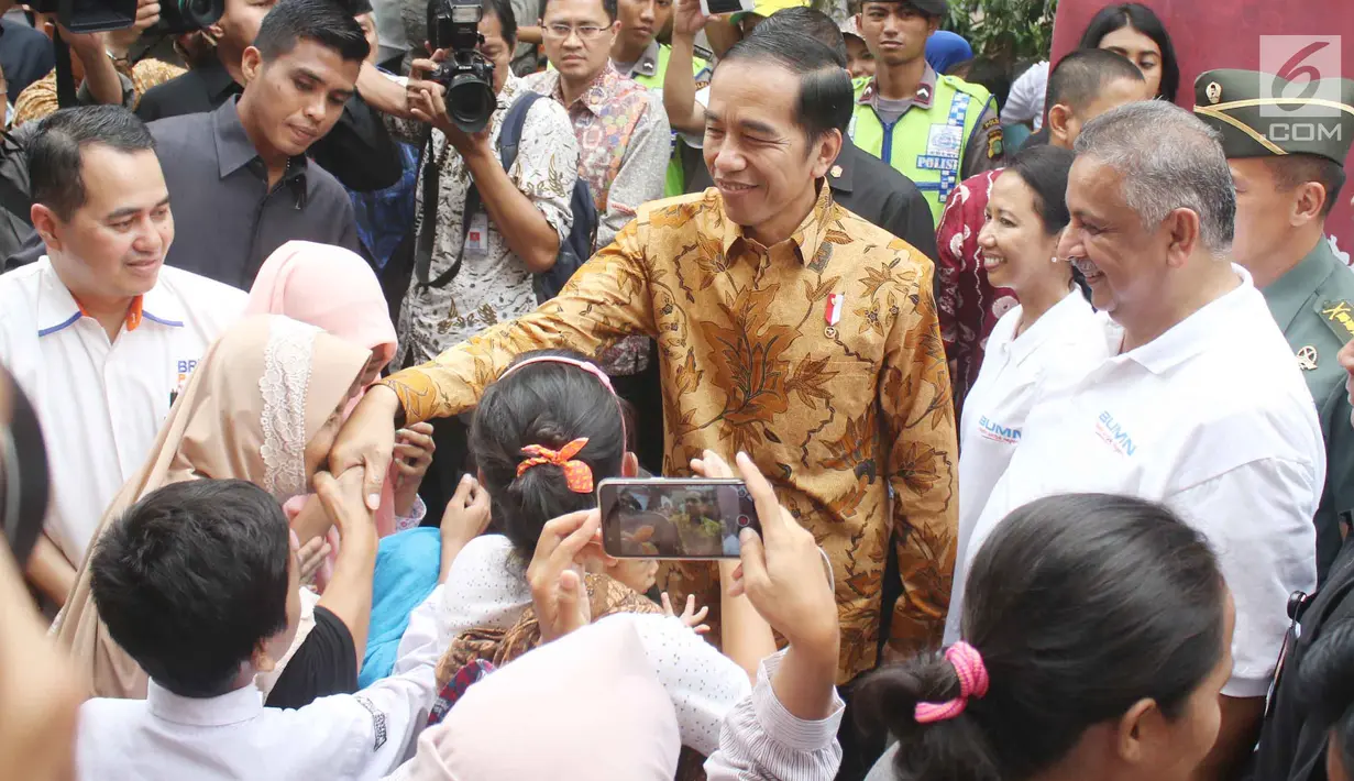 Presiden Jokowi bersalaman dengan warga saat menyaksikan pembagian paket Ramadan berupa sembako di Penjaringan, Jakarta, Selasa (13/6). Pembagian sembako ini merupakan inisiasi dari Kementerian BUMN dan perusahaan BUMN lainnya (Liputan6.com/Angga Yuniar)