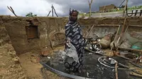 Seorang wanita berdiri di dalam rumahnya yang rusak setelah bentrokan etnis di negara bagian Nil Biru Sudan, di kota Roseires, Sudan tenggara (8/8/2022). Bentrokan etnis dalam sengketa tanah yang mematikan di negara bagian Nil Biru Sudan telah menewaskan 105 orang dan melukai 291, kata menteri kesehatan negara bagian itu. (AFP/Ashraf Shazly)