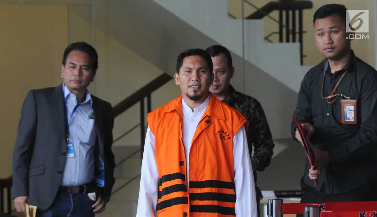 Bupati Bener Meriah nonaktif Ahmadi menggenakan rompi oranye usai menjalani pemeriksaan lanjutan di KPK, Jakarta, Jumat (31/8). Ahmadi diperiksa terkait suap proyek infrastruktur dari Dana Otonomi Khusus Aceh Anggaran 2018. (Merdeka.com/Dwi Narwoko)