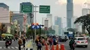 Warga menunggu angkutan umum di tepi Jalan Jenderal Sudirman, Jakarta, Senin (8/7/2019). Tidak adanya halte tersebut mengurangi kenyamanan serta mengganggu arus lalu lintas. (Liputan6.com/Immanuel Antonius)